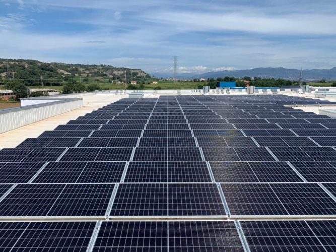 Grande conjunto de módulos fotovoltaicos instalado sobre uma cobertura.